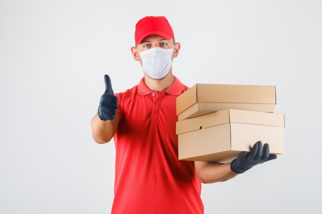 Employee holding boxes wearing a mask
